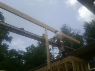 Carpenter setting a ridge beam over a new addition frame — Ice Dam Removal by Roofing Brothers in Kennett Square