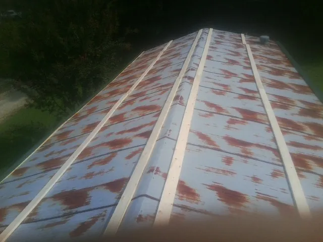 Rusted metal roof panels with new wood purlins before replacement — Storm Damage Roof Repair in Kennett Square by Roofing Brothers