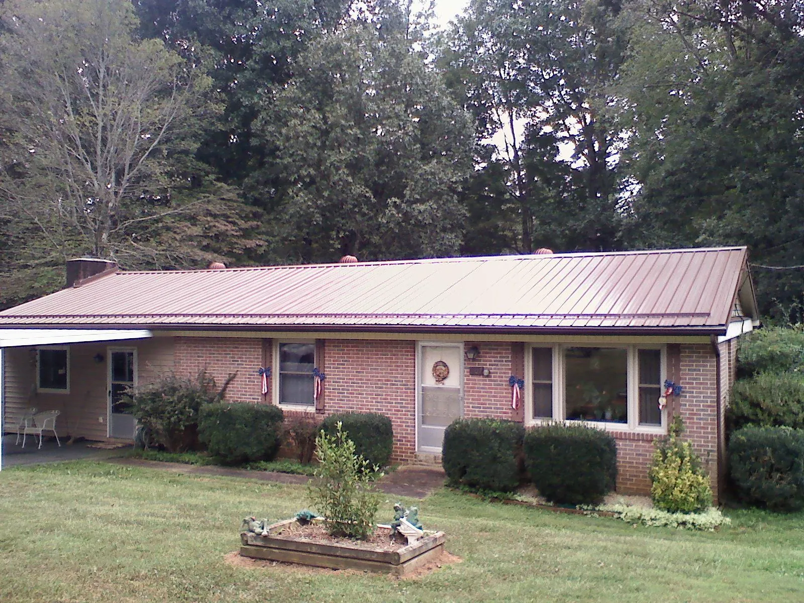 Bronze metal roof on a brick ranch home with a carport in Kennett Square