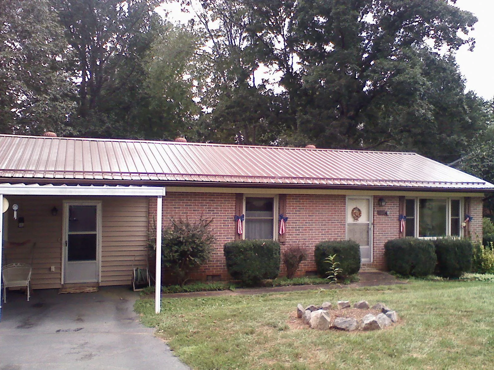 Bronze metal roof and carport on a brick ranch home — Roof Repair work by our crew in Kennett Square